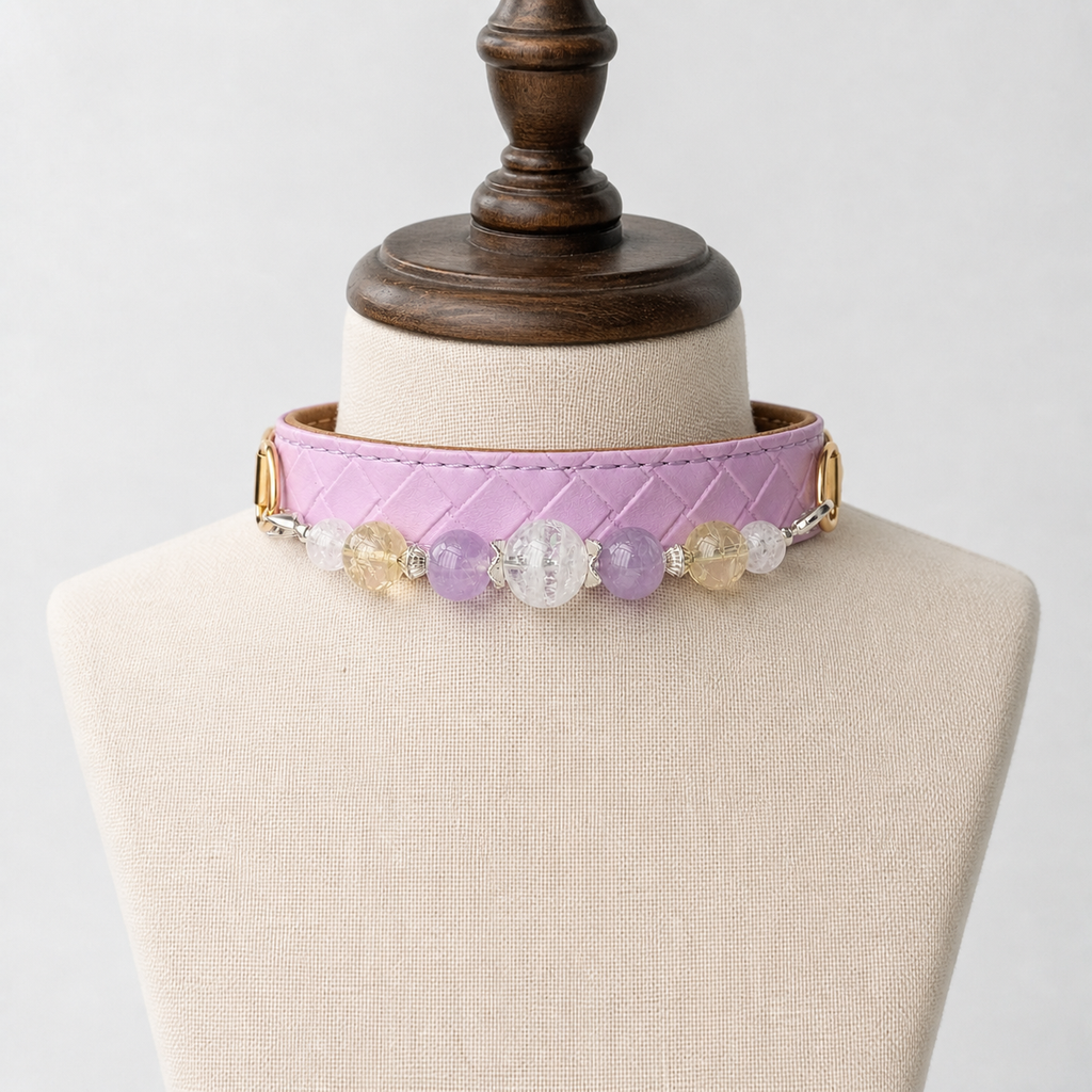 Lavender crystal beaded pet collar displayed on a cream stand