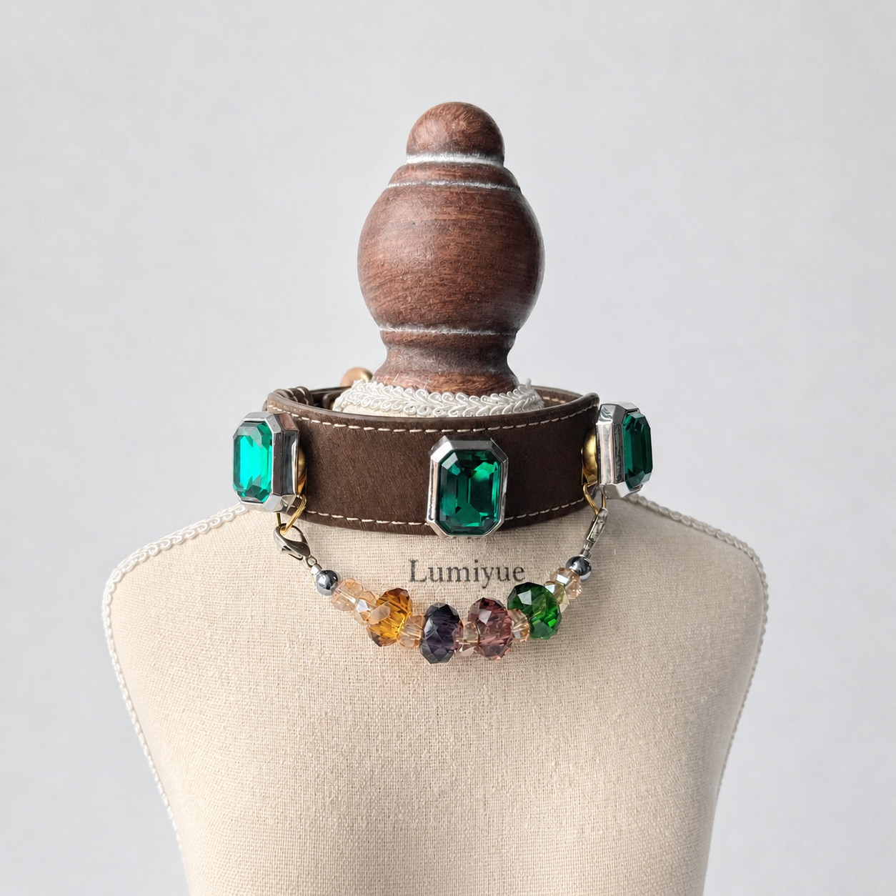 Brown green crystal charm dog collar displayed on a cream Lumiyue stand