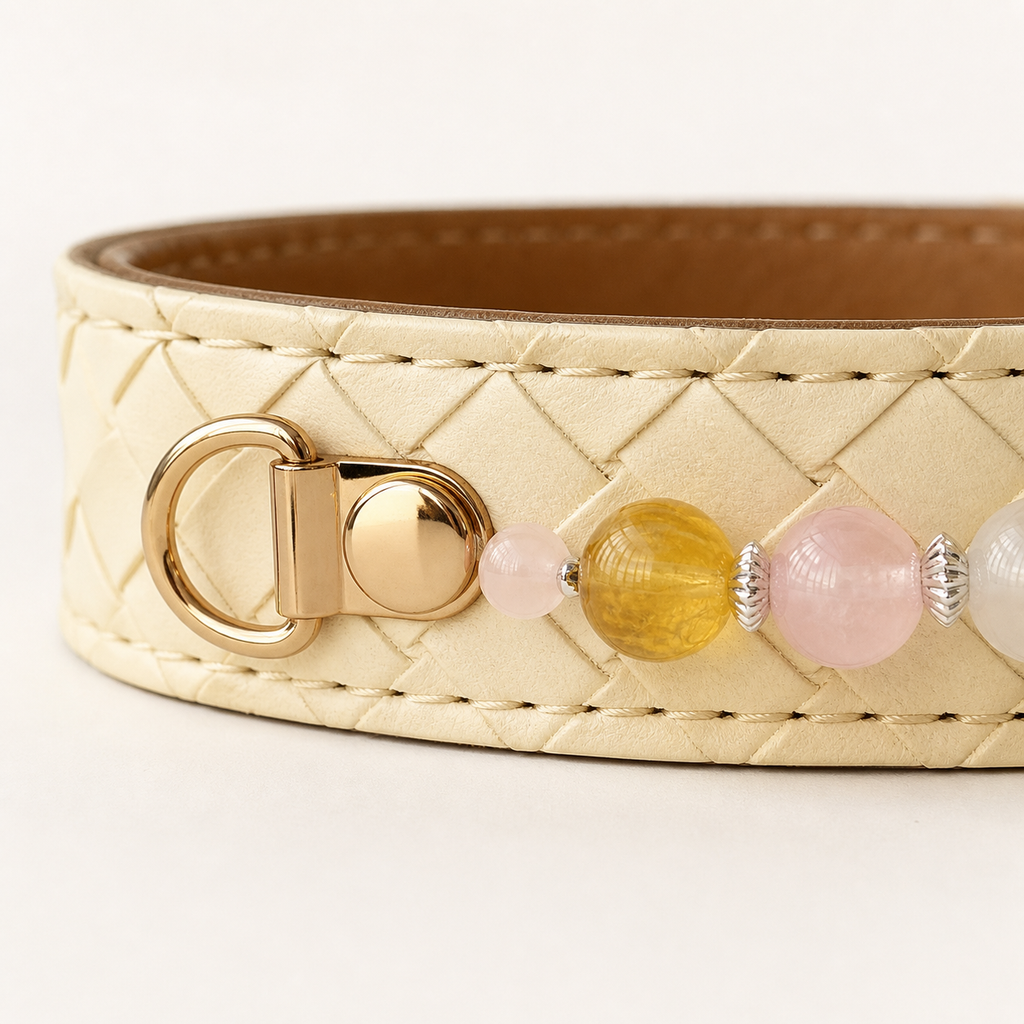Close-up of ivory basketweave stitching, gold-tone connector and pastel beads